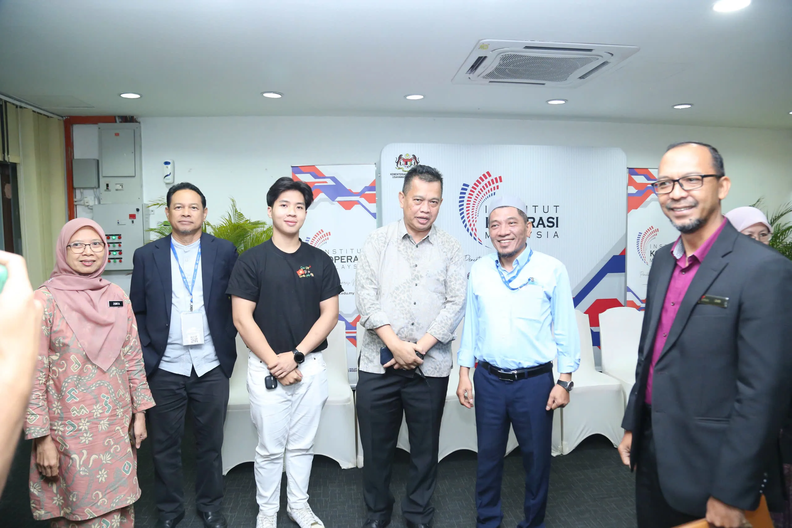 Đoàn công tác trước backdrop Institut Koperasi Malaysia